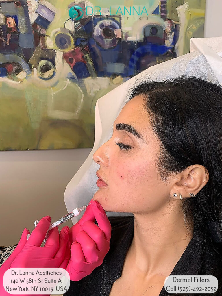 a woman receives chin filler injection at a beauty clinic