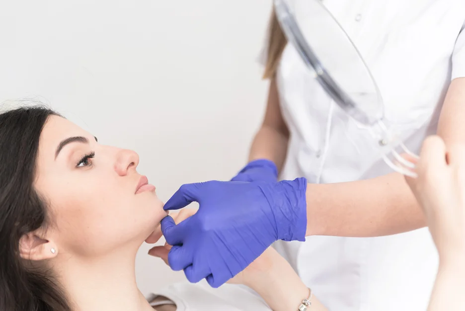 medical provider checks the chin area of the client to inject the dermal fillers 