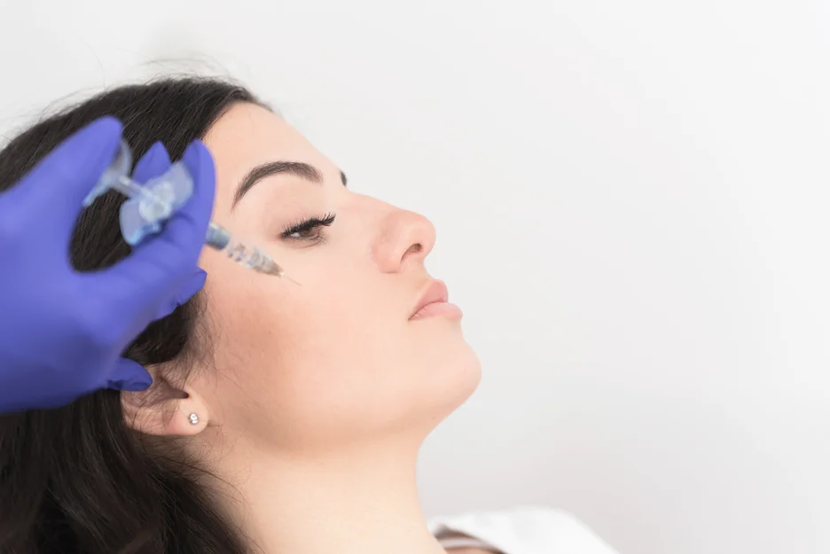 A young woman getting dermal filler on cheeks